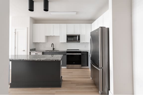 A modern kitchen with a refrigerator on the right.