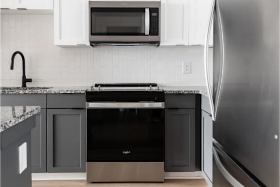 A modern kitchen with a black oven and a silver refrigerator.