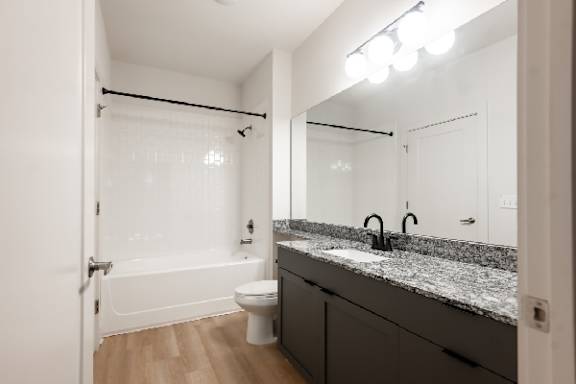 A white bathroom with a toilet, sink, and tub.