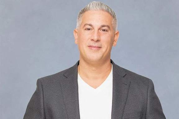 A man with silver hair wearing a grey blazer and white shirt at Residences Providence, Providence, RI