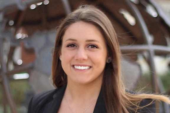 A woman with long brown hair wearing a black blazer and a necklace at Residences Providence, Providence, 2903