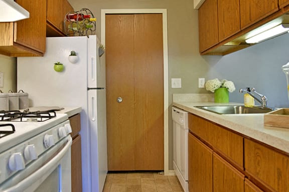 Galley Style Kitchen with White Appliances at Stone Ridge Apartments, Wixom