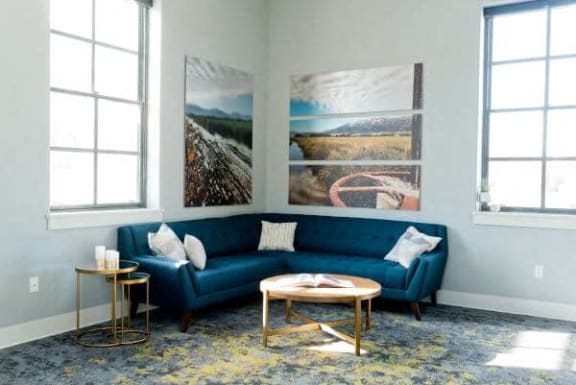 a living room with a blue couch and two tables