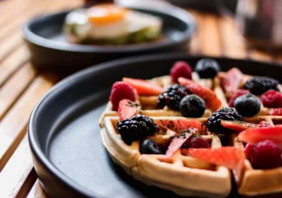 a plate with a waffle and fruit on it
