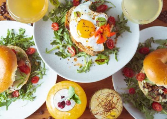 a white plate topped with a fried egg on top of a salad