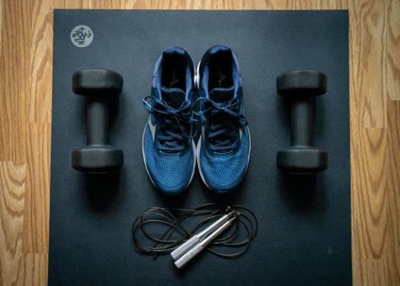 a pair of blue shoes sitting next to weights