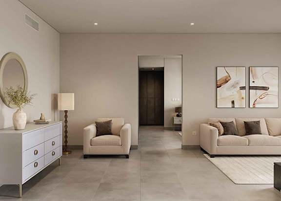 A modern living room with a white sofa, a white side table, and a white dresser.