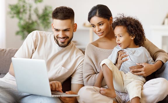 Family on couch looking an laptop