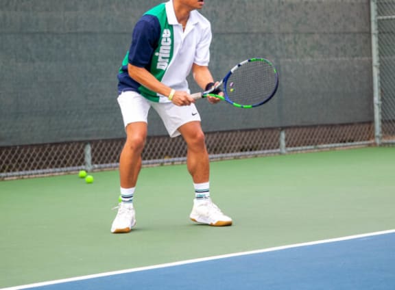 A man in a green and white shirt is playing tennis. at SMB Hollywood Apartments, Los Angeles, CA, 90038