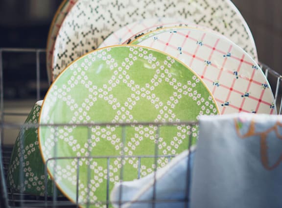 a basket filled with green and white plates
