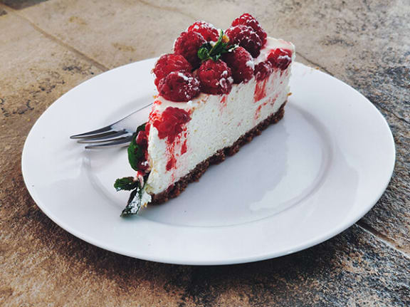 a piece of cake on a white plate with a fork