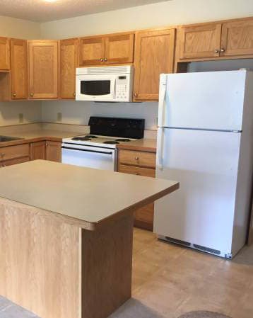 a kitchen with a white stove top oven next to a refrigerator