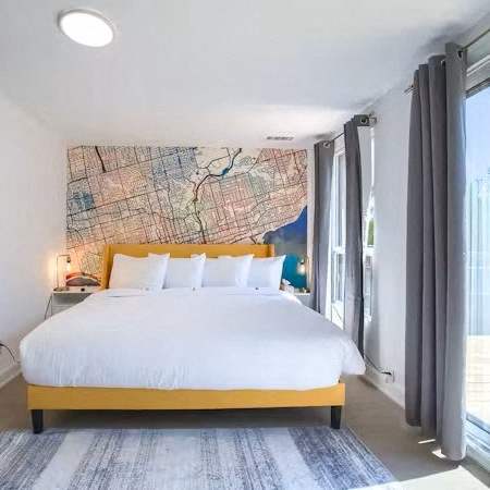 A bedroom with a large bed and a map on the wall.