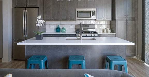 a kitchen with blue stools in front of a counter