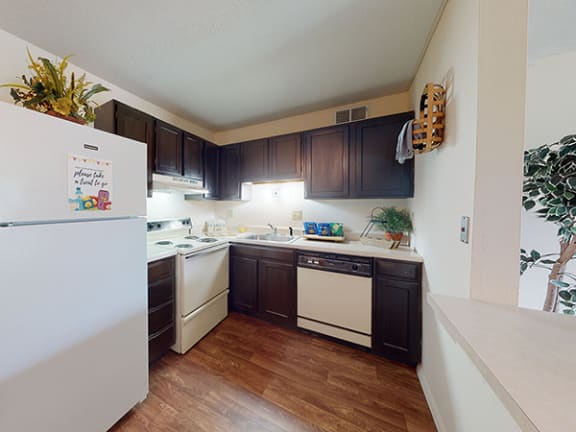 a kitchen with dark cabinets and white appliances