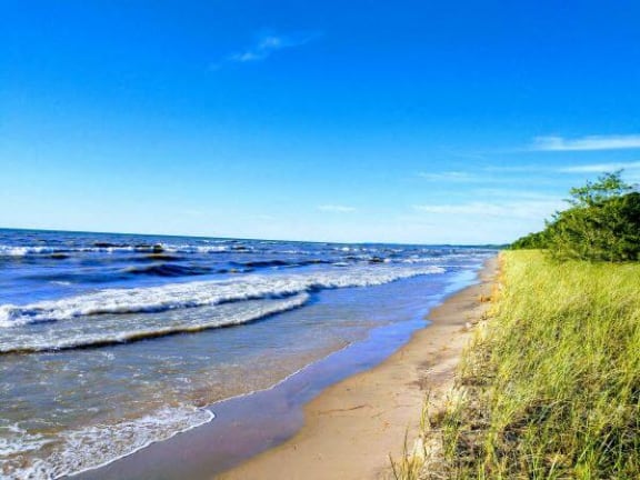 a sandy beach next to a body of water