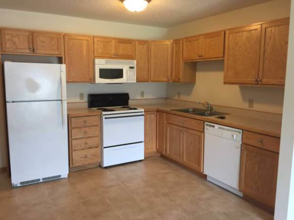 a kitchen with white appliances and wooden cabinets