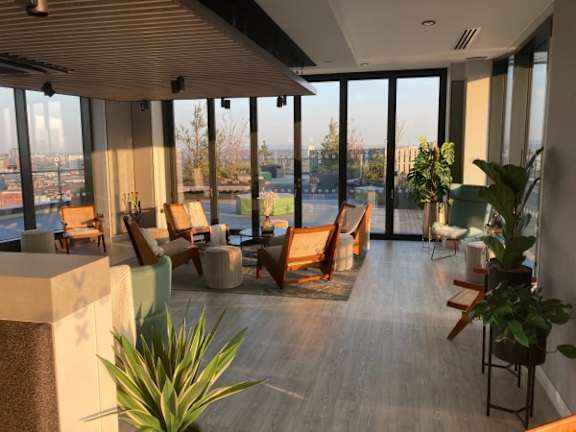 a lobby with chairs and a view of the city at Vox Apartments, Manchester