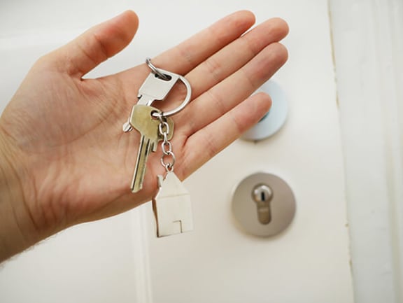 a hand holding a set of keys in front of a door
