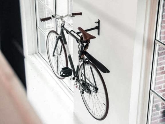 a bike hanging in a window on a wall