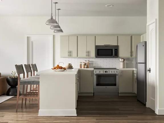 A modern kitchen with a white island and stainless steel appliances at The SoHo Luxury Apartments, Raleigh