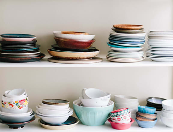 a shelf full of plates and bowls