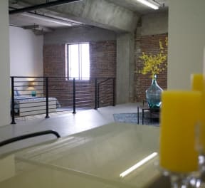 a room with a bath tub and a vase with yellow flowers at Binford Lofts Apartments, Los Angeles , California
