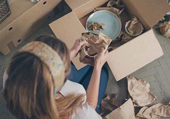 a woman sitting in a box with a plate of food