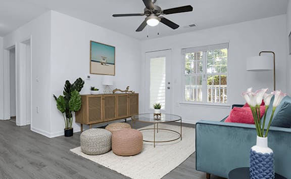 A living room with a ceiling fan and a painting on the wall.