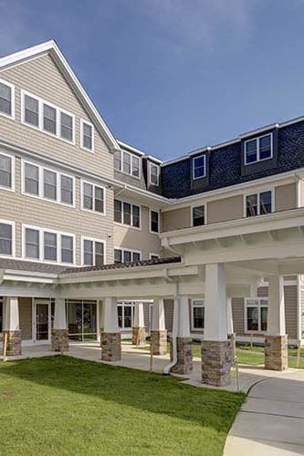 a large building with a walkway in front of it at The Bodhi at Island Creek Village, Duxbury, 02332
