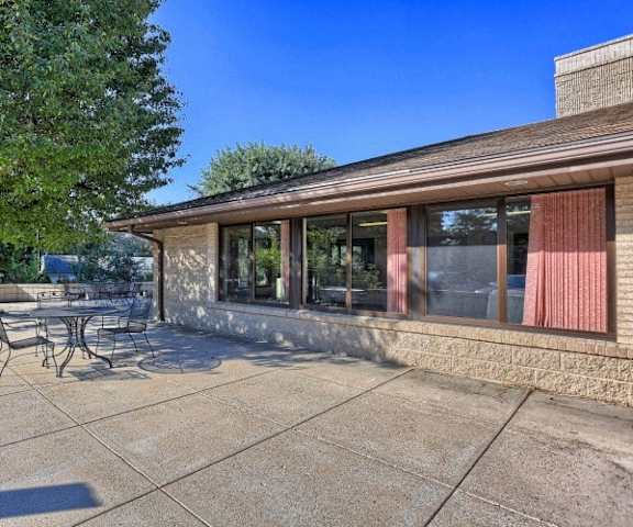 a patio with tables and chairs outside of a building