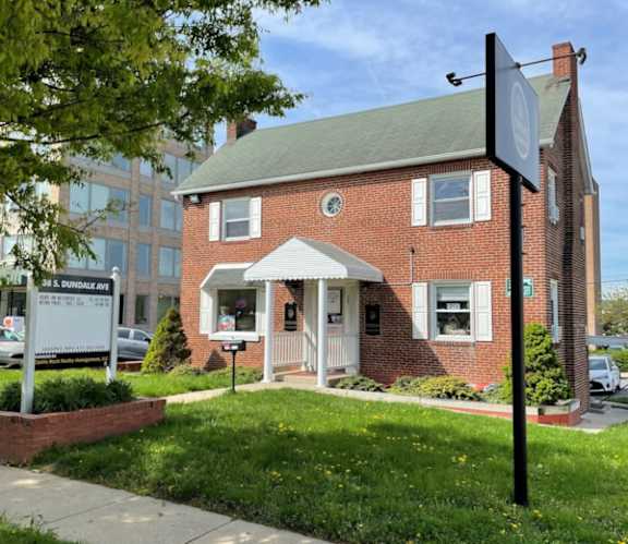 A brick house with a sign in front of it.
