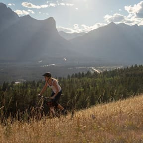 a man riding a bike up a hill