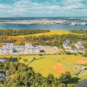 A baseball field is in the foreground of a scenic overview of Daniel Island.