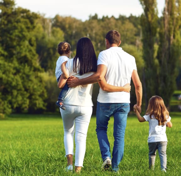 a family walking through a park with their daughter