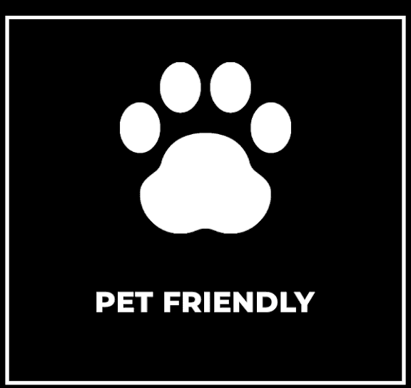 A sign with a paw print and the words "PET FRIENDLY" on a black background.