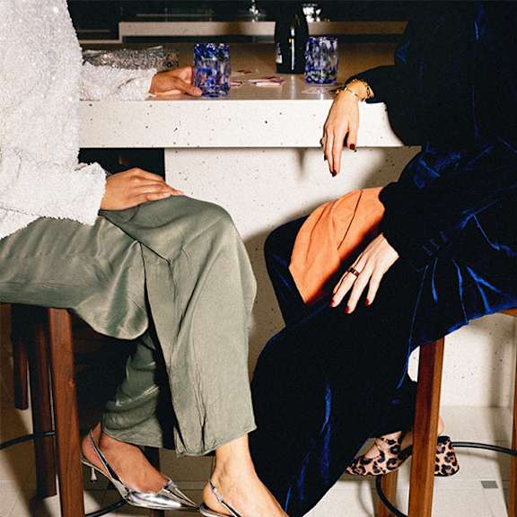 A person is playing cards with two blue glasses on the table.