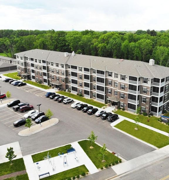 an aerial view of an apartment building and parking lot