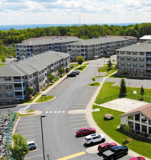 an aerial view of an apartment complex with cars parked in a parking lot