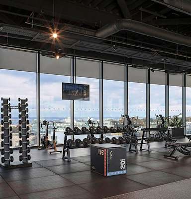 A gym with a view of the water outside the windows.