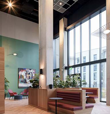 A reception area with a wooden counter and red seating.