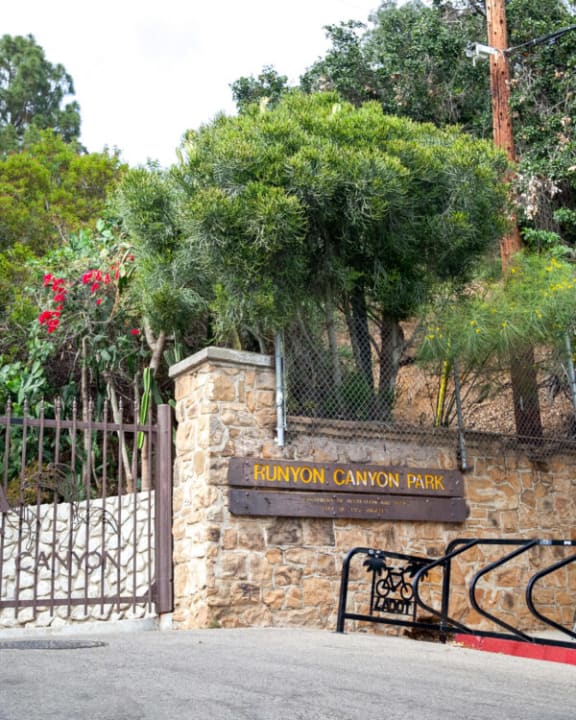 A sign that says FUNYON CANYON PARK is on a stone wall. at SMB Hollywood Apartments, California, 90038