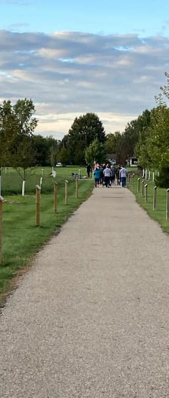 people walking down a path in a cemetery