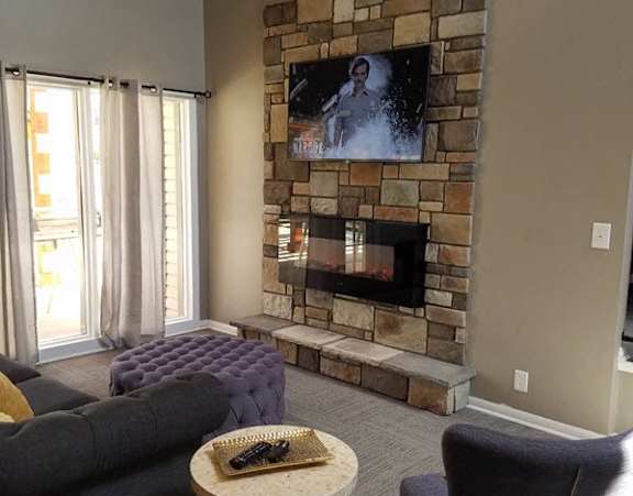 a living room with a fireplace and a tv on the wall