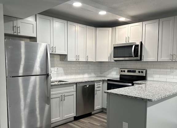 Renovated kitchen with stainless steel appliances and upgraded cabinets, flooring, and  counter tops at Stuart Woods* Apartments, Herndon, 20170