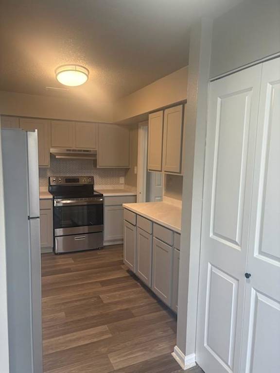 A kitchen with white cabinets and a stainless steel oven.