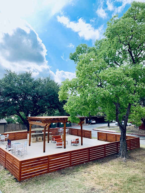 Outdoor patio deck with pergola and horizontal slat fencing at The Colony Apartments, Universal City, TX