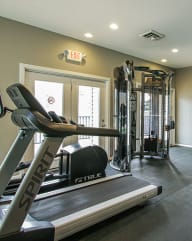 a treadmill and other exercise equipment in the fitness room