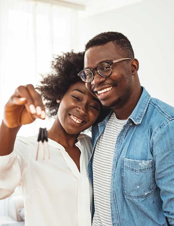 a man and woman are smiling and holding up their engagement rings