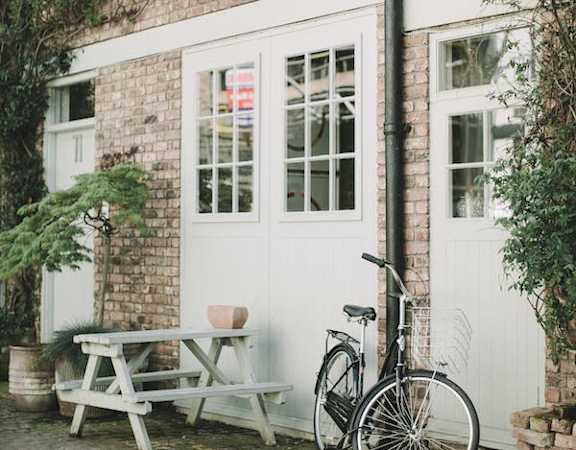 a bicycle and picnic table in front of a brick building